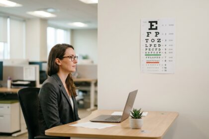 Femme portant des lunettes passant un bilan de vue au bureau dans un environnement de travail moderne