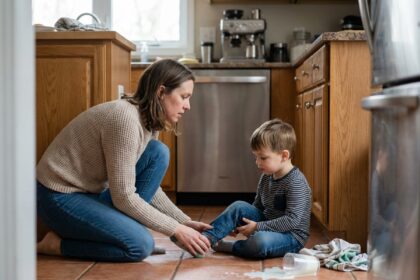 Femme rassurante vérifiant la blessure d'un enfant dans la cuisine