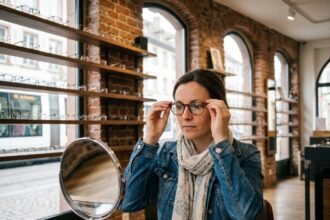 Femme en optique essayant des lunettes à Strasbourg
