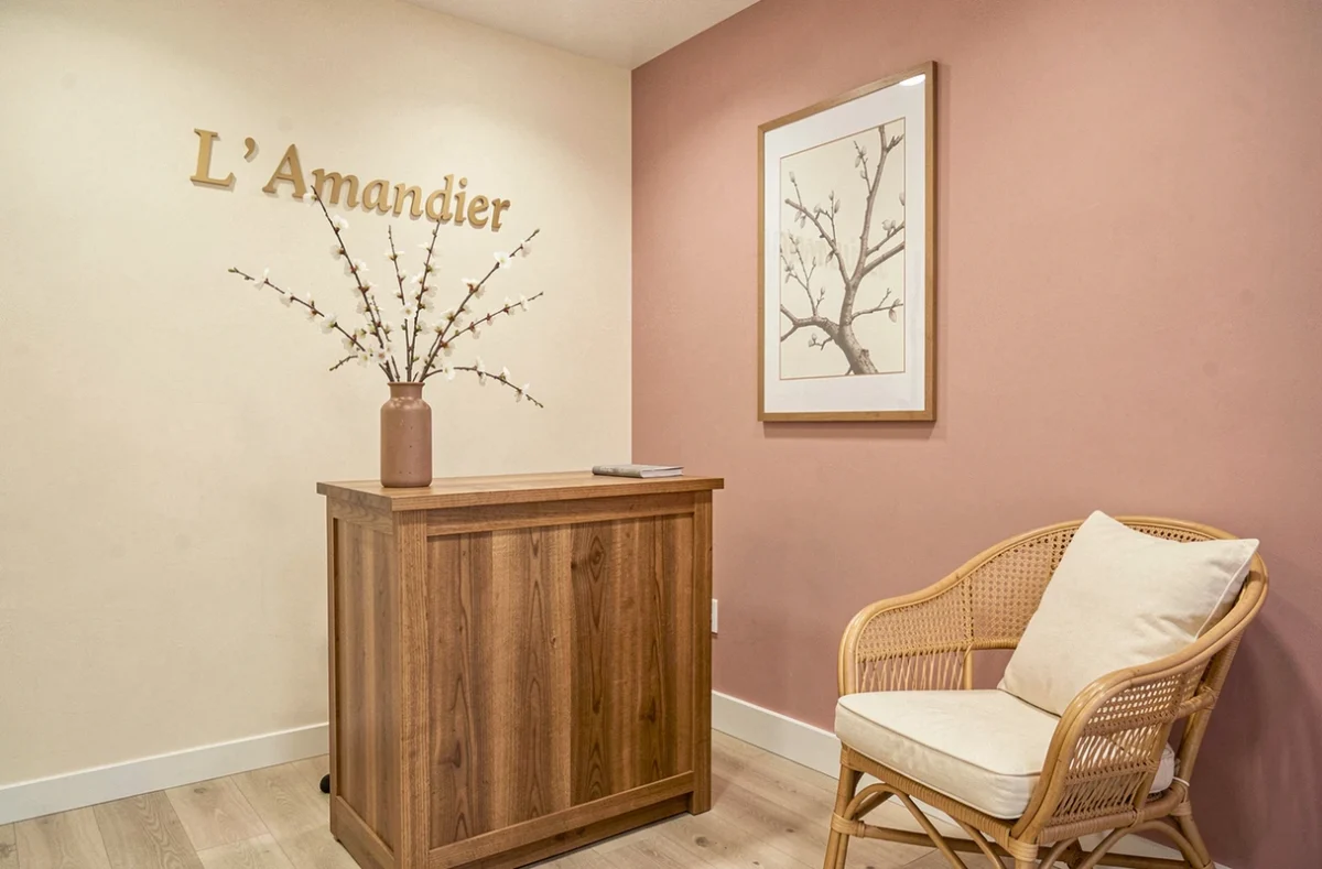 Salle d'accueil du cabinet d'acupuncture L'Amandier avec des fleurs d'amandier, mobilier en bois et atmosphère zen
