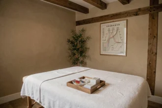Salle de soins d'acupuncture dans le Grand Est avec table de traitement, aiguilles stériles et graphiques de méridiens traditionnels chinois